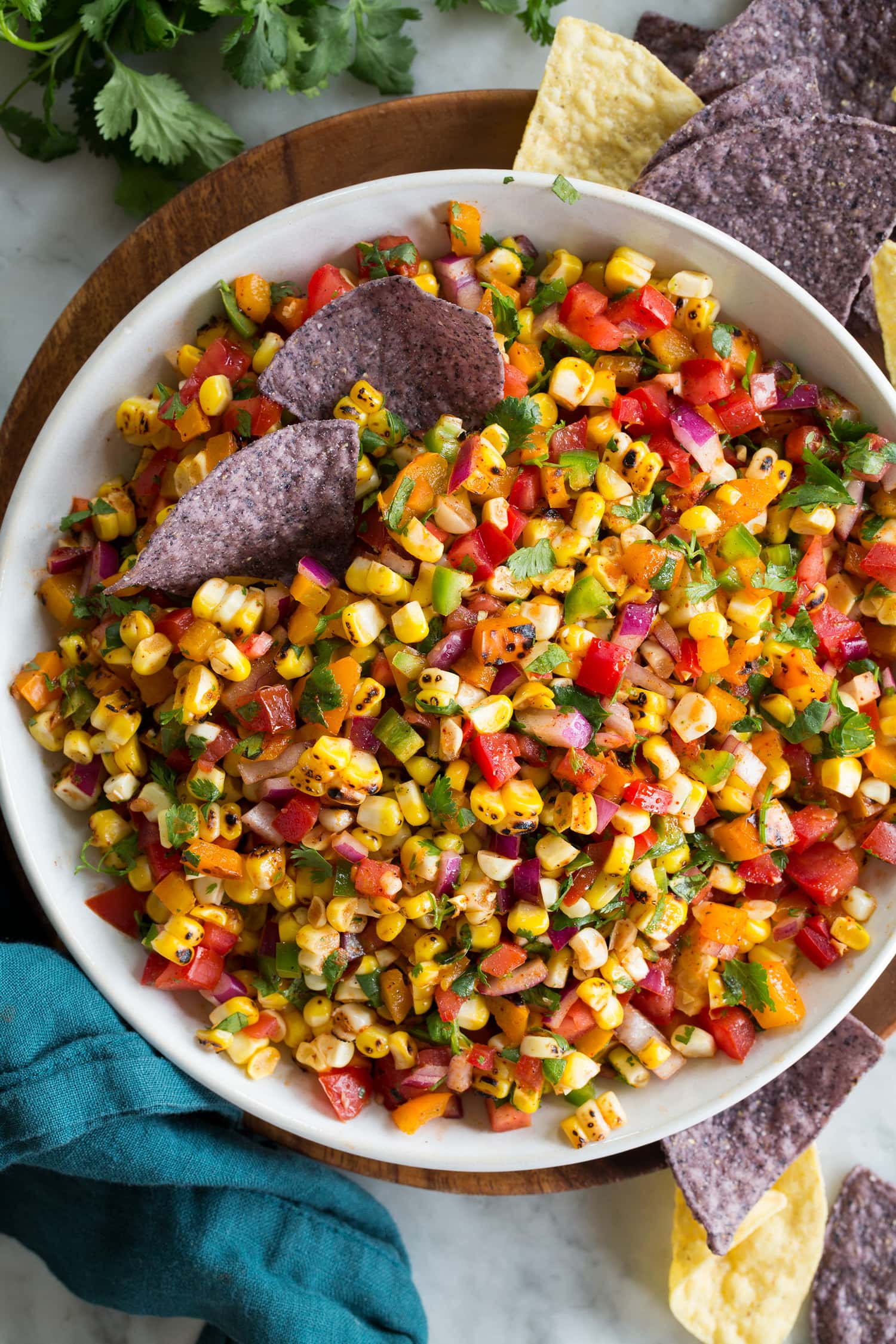 Overhead photo of corn salsa with tortilla chips dipped in.