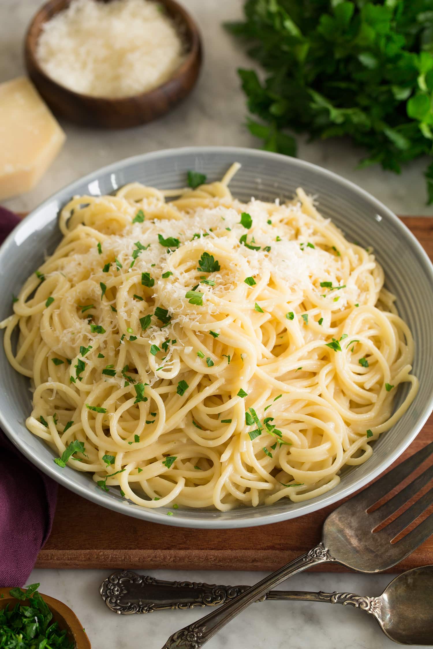 Garlilc Parmesan pasta served in a gray pasta bowl over a wooden tray.