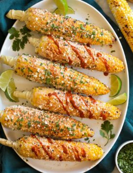 Elotes Grilled Mexican Street corn with cotija cheese, mayo crema, hot sauce and cilantro.